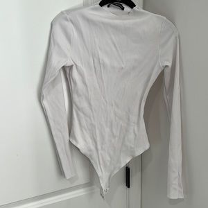 Never worn White, long sleeve, bodysuit. Size XL.